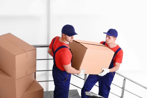 Movers carrying furniture through a narrow Stockwell staircase